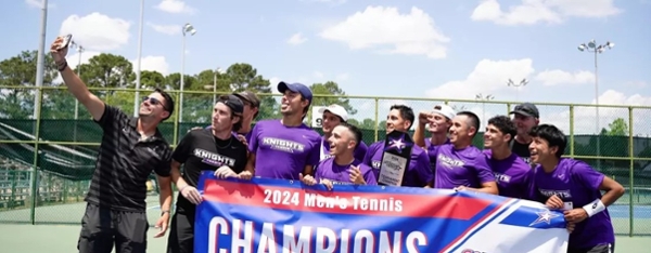 Knights men's tennis team with their SSAC Championship banner.